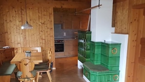 En inredning med träpaneler, ett matområde, ett kök och förvaringsutrymmen.
