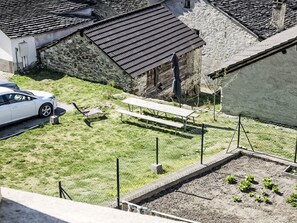 A residential area with a stone building, a white car, and a picnic table. - Waterfall House by Interhome (Mesocco)