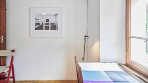 A room with a bed, a window, a door, and a framed picture on the wall. - Waterfall House by Interhome (Mesocco)