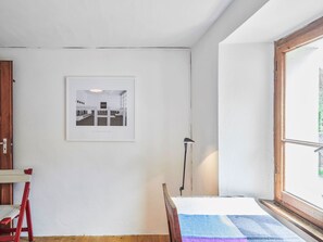 A room with a bed, a window, a door, and a framed picture on the wall. - Waterfall House by Interhome (Mesocco)