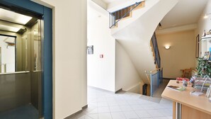 A hotel lobby with a staircase, a reception desk, and a view of the upper floor. - Villa Celia Sellin by Interhome (Ostseebad Sellin)