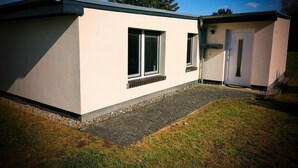 Ein modernes Gebäude mit flachem Dach, einer kleinen Veranda und einer Tür.