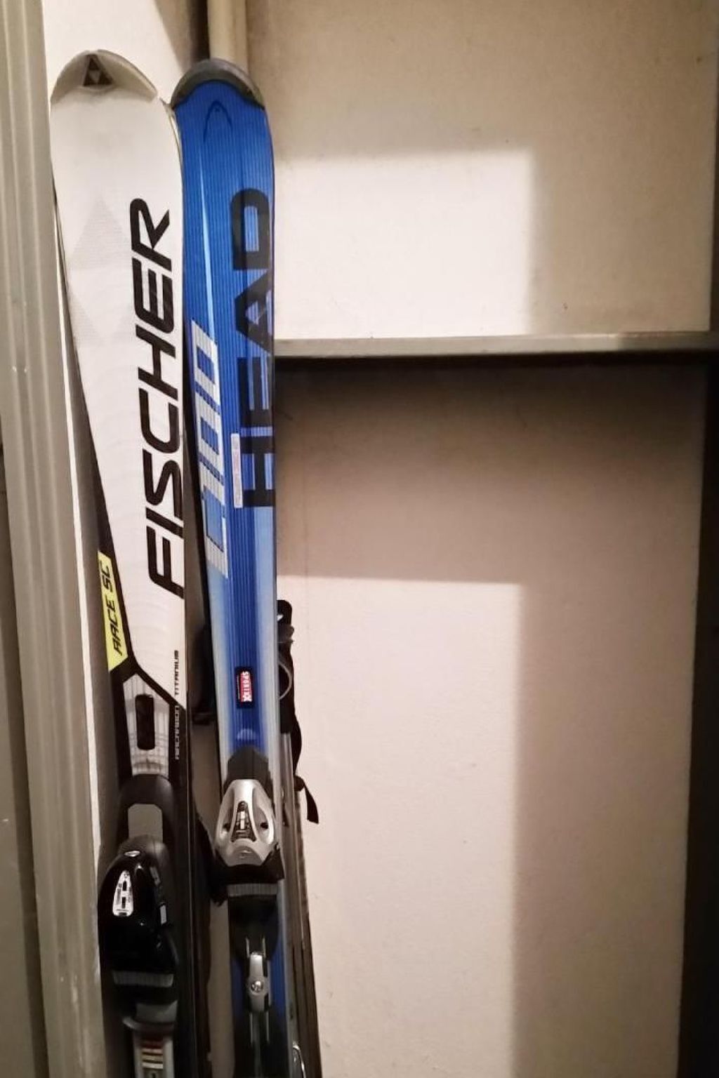 Two skis leaning against a wall.