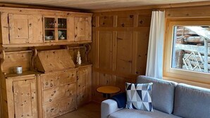 L’intérieur d’une cabane avec des murs en bois et un canapé.