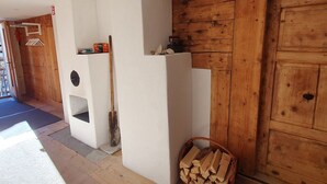 Une pièce avec une cheminée, une porte en bois et un panier de bois de chauffage.