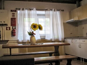 A kitchen with a window, a vase with sunflowers, a fire extinguisher, and a stove. - Dornes, das mythische Land der Tempelritter by Interhome (Dornes)