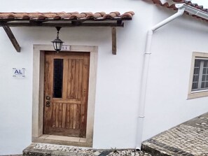 A white building with a wooden door, a small window, and a tiled roof. - Dornes, das mythische Land der Tempelritter by Interhome (Dornes)
