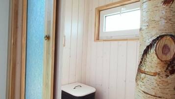 Una habitación pequeña y acogedora con paredes de madera y una ventana.