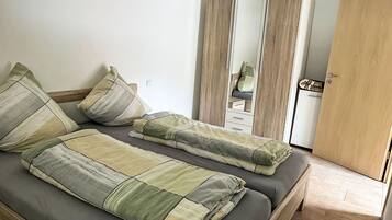 Ein Zimmer mit einem Bett, einem Kleiderschrank und einem Spiegel.