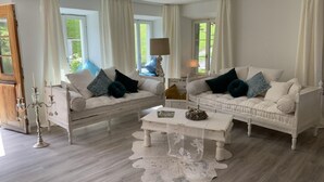 Ein Wohnzimmer mit zwei weißen Sofas, einem Couchtisch und einer Chandelier.