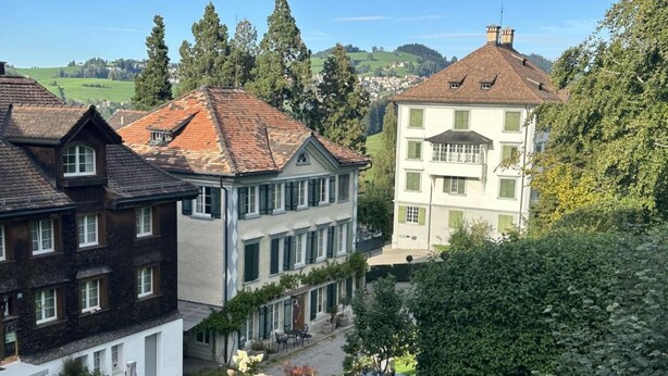 Ein Gebäude im traditionellen europäischen Stil mit Garten-Terrasse und Blick auf die umliegende Landschaft.