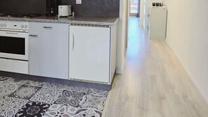 A modern kitchen with white cabinetry, a microwave, a coffee maker, and a refrigerator. - L'Ecrin de Torgon in den Portes du Soleil by Interhome (Torgon)