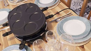 A dining table set with plates, glasses, and a waffle maker. - L'Ecrin de Torgon in den Portes du Soleil by Interhome (Torgon)