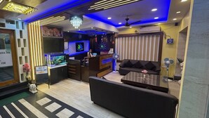 Eine Hotelhalle mit Empfangsschalter, Sitzgelegenheiten und einer großen Chandelier.