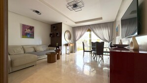 Uma sala de estar moderna com sofá, mesa de centro e área de jantar.