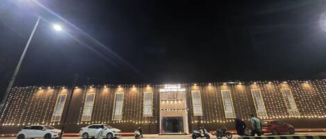 A building with multiple windows and a well-lit facade, likely a hotel or similar establishment.