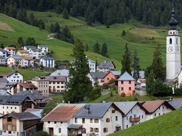 A village with traditional houses, a church, and a clock tower. - Chasa Semadeni by Interhome (Ftan)