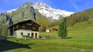 A mountain lodge with a wooden exterior, a covered porch, and a sign reading "Chalet". - Pensiun Tung by Interhome (Vnà)