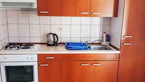 Eine Küche mit Herd, Backofen, Spüle und Holzausstattung.