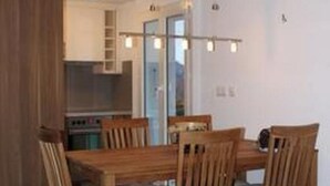 A dining area with a wooden table and chairs, a kitchen in the background, and a ceiling with recessed lighting. - Adlerhorst by Interhome (Rosswald)