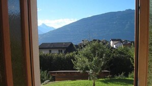 Une porte donnant sur un parking avec vue sur la montagne.