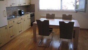 Une cuisine compacte avec des meubles en bois, un four encastré et une fenêtre qui laisse entrer la lumière naturelle.