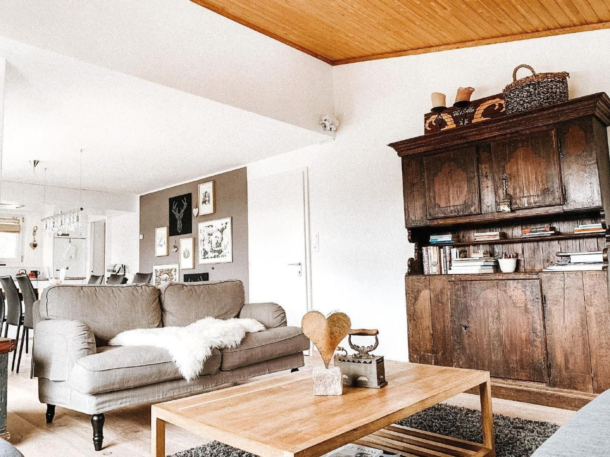 Un salon avec un canapé, une table basse et un meuble en bois contenant des livres.