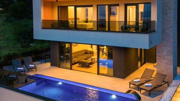A modern two-story house with a balcony, a swimming pool, and outdoor seating. - Villa Mario by Interhome (Bast)