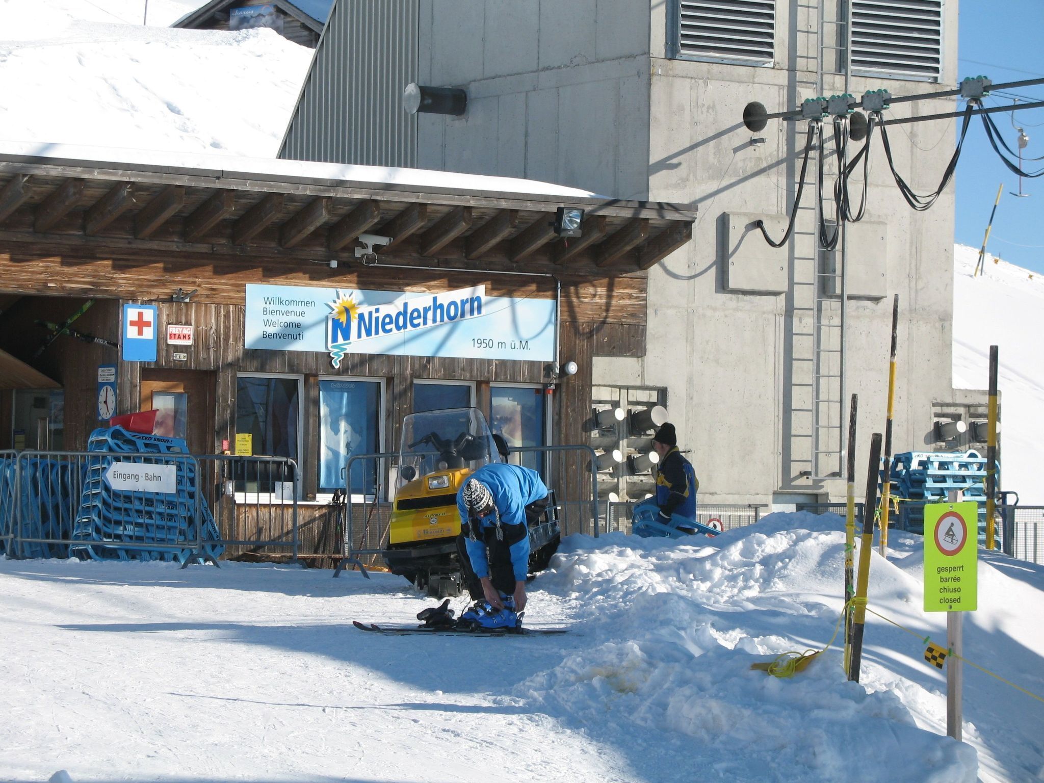 Une station de ski avec un panneau indiquant « Niederhorn » et un indicateur de distance indiquant « 1950 m au-dessus du niveau de la mer ».