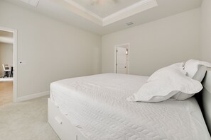 Una camera da letto con un letto grande, una porta e una ventola a soffitto.