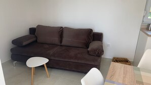 Un soggiorno moderno con un divano marrone, un tavolino bianco e un tappeto decorato.