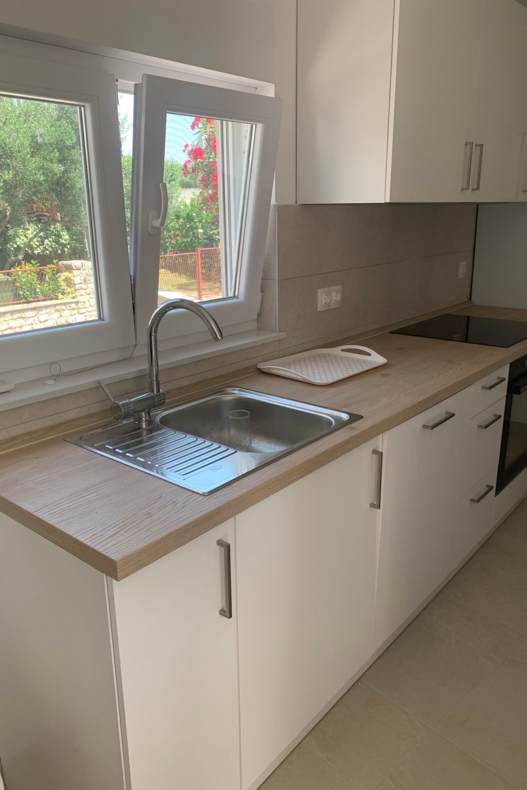 Een koelkast, een oven, een vaatwasser, kookgerei, borden en bestek