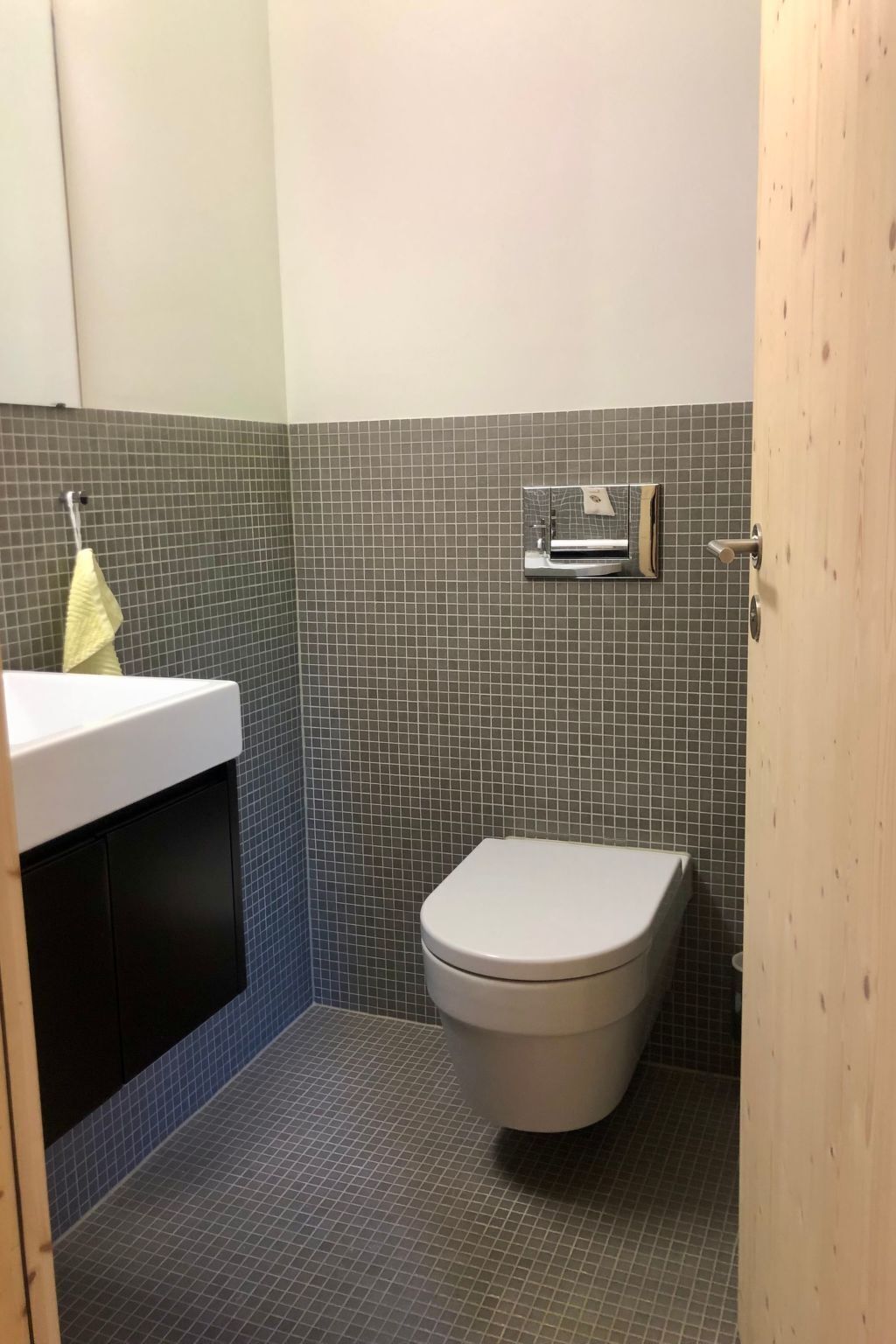 Un bagno piccolo con il water, un lavandino e uno specchio.