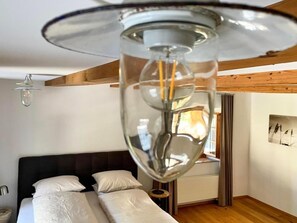 Ein modernes Schlafzimmer mit Bett, Nachttischen und einer Deckenleuchte.