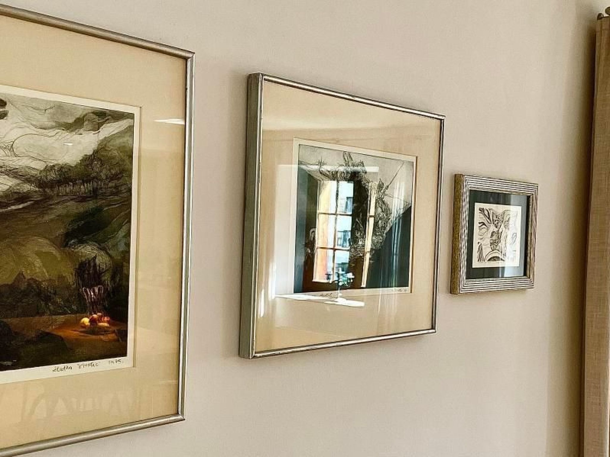 Três obras de arte emolduradas numa parede.