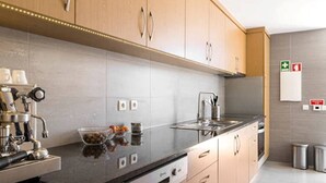 Een koelkast, een oven, een vaatwasser, kookgerei, borden en bestek