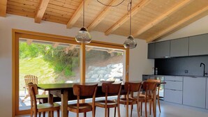 A modern kitchen with a stone countertop and wooden cabinets. - Casa Campanula by Interhome (Laax)