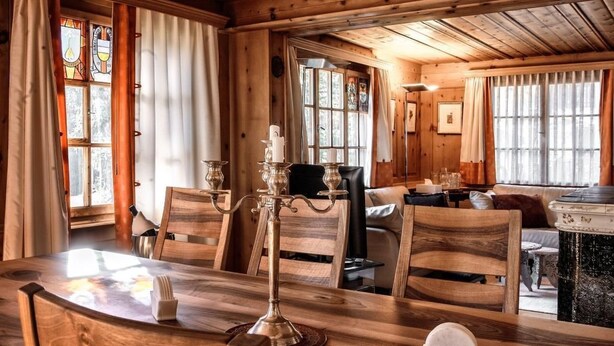 Un interior de madera con una mesa de comedor, sillas y un candelabro.