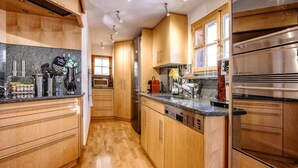 Una cocina moderna con armarios de madera, electrodomésticos de acero inoxidable y encimera de granito.