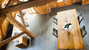 A wooden dining table with chairs, a wooden cabinet, and a window with a view of the outdoors.