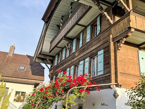 Ein traditionelles Holzgebäude mit mehreren Fenstern und Balkonen, eine sichtbare Tür mit dem Schriftzug 'PRIVATE' und ein kleines Fenster mit Blick zum Himmel.