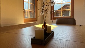 A room with a tatami mat floor, a wooden table with candles, and a vase with dried flowers. - Steirufina by Interhome (Bellwald)