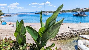 Eine Küstenlandschaft mit Booten, einem Strand und einer felsigen Uferlinie.