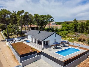 A modern house with a swimming pool, a covered patio, and a garden. - Vacation home  by Interhome (Vir)