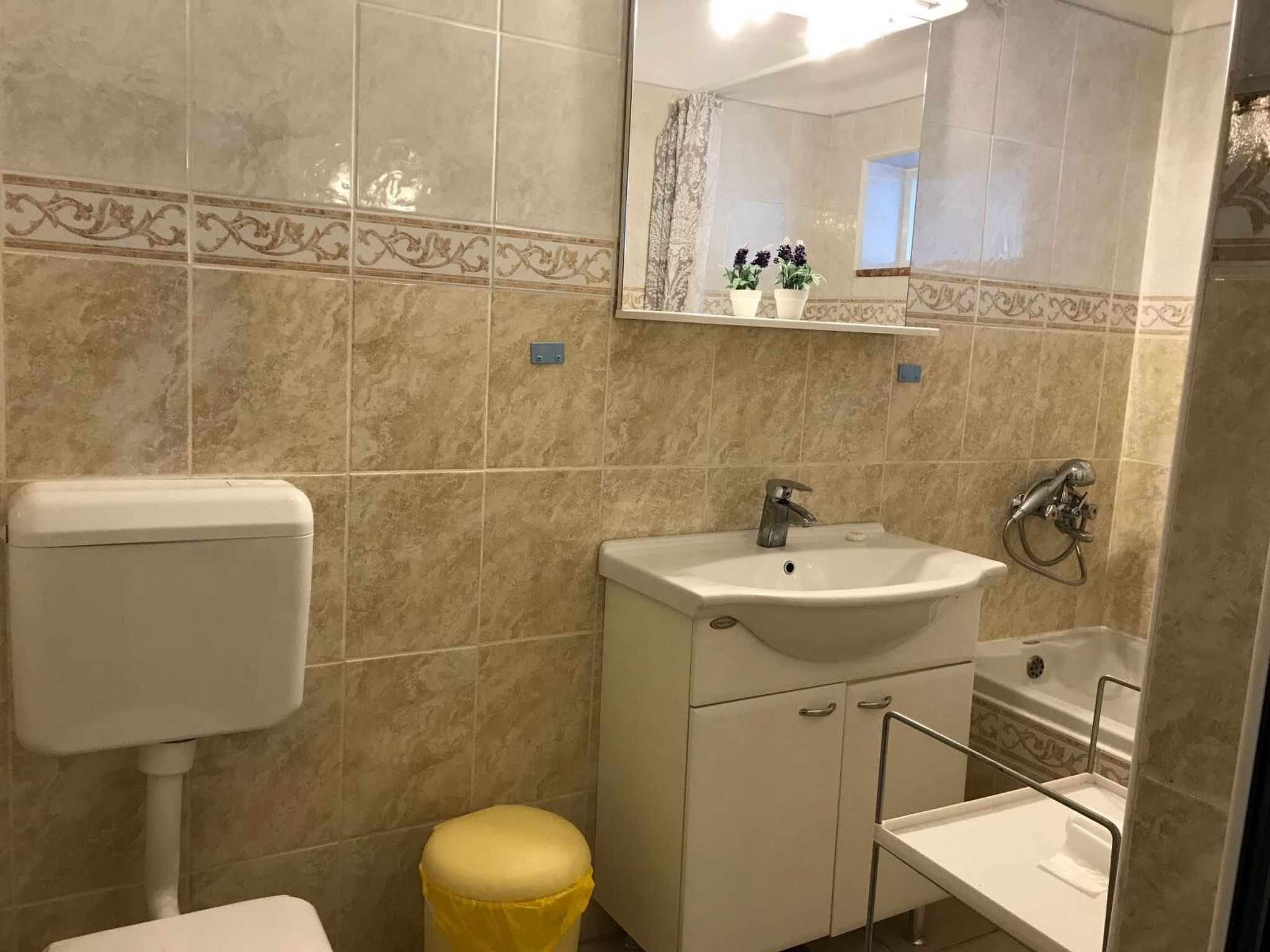 A bathroom with a toilet, sink, and shower.