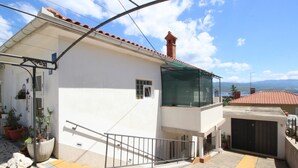 A modern two-story house with a balcony, a small window, and a door. - Apartment Renata by Interhome (Polje)