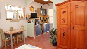 A compact kitchen with a dining area, a TV, and a wooden cabinet. - Apartment Renata by Interhome (Polje)