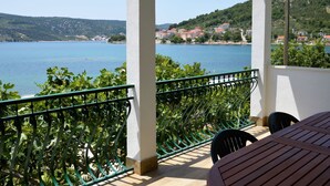 Ein Balkon mit Blick auf einen See und Hügelhäuser.