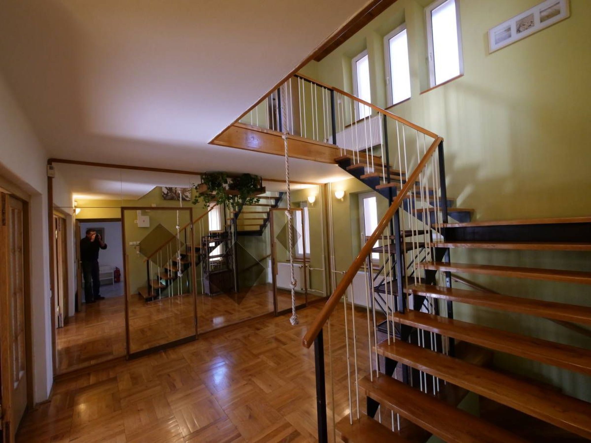 A wooden staircase with a glass railing, leading to an upper floor.