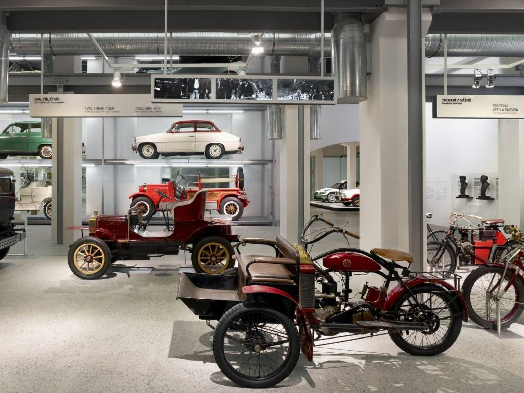 A museum exhibit with vintage cars and bicycles.